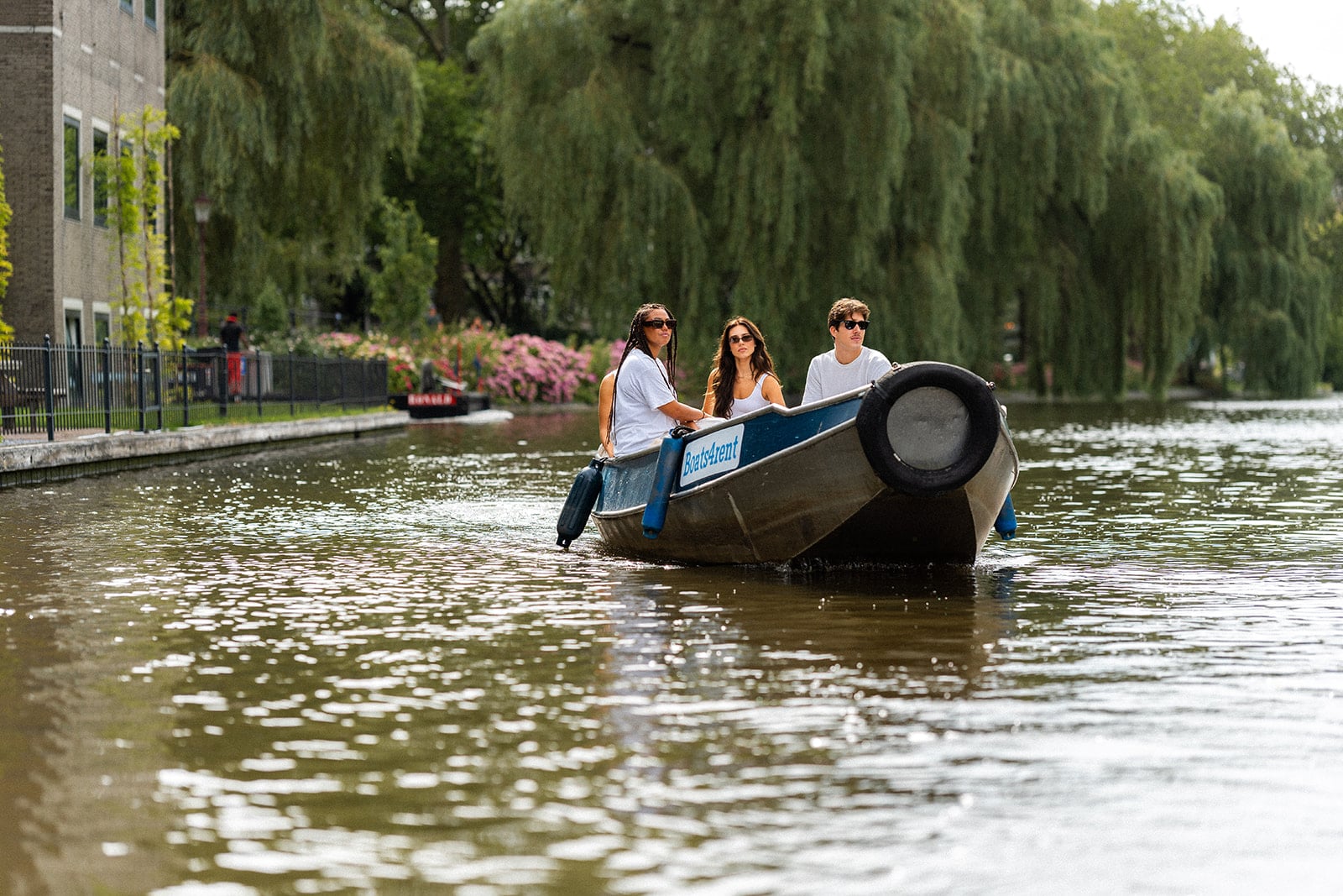 Vrienden genieten van sloep huren op de Amsterdamse grachten — ideaal als kadobon