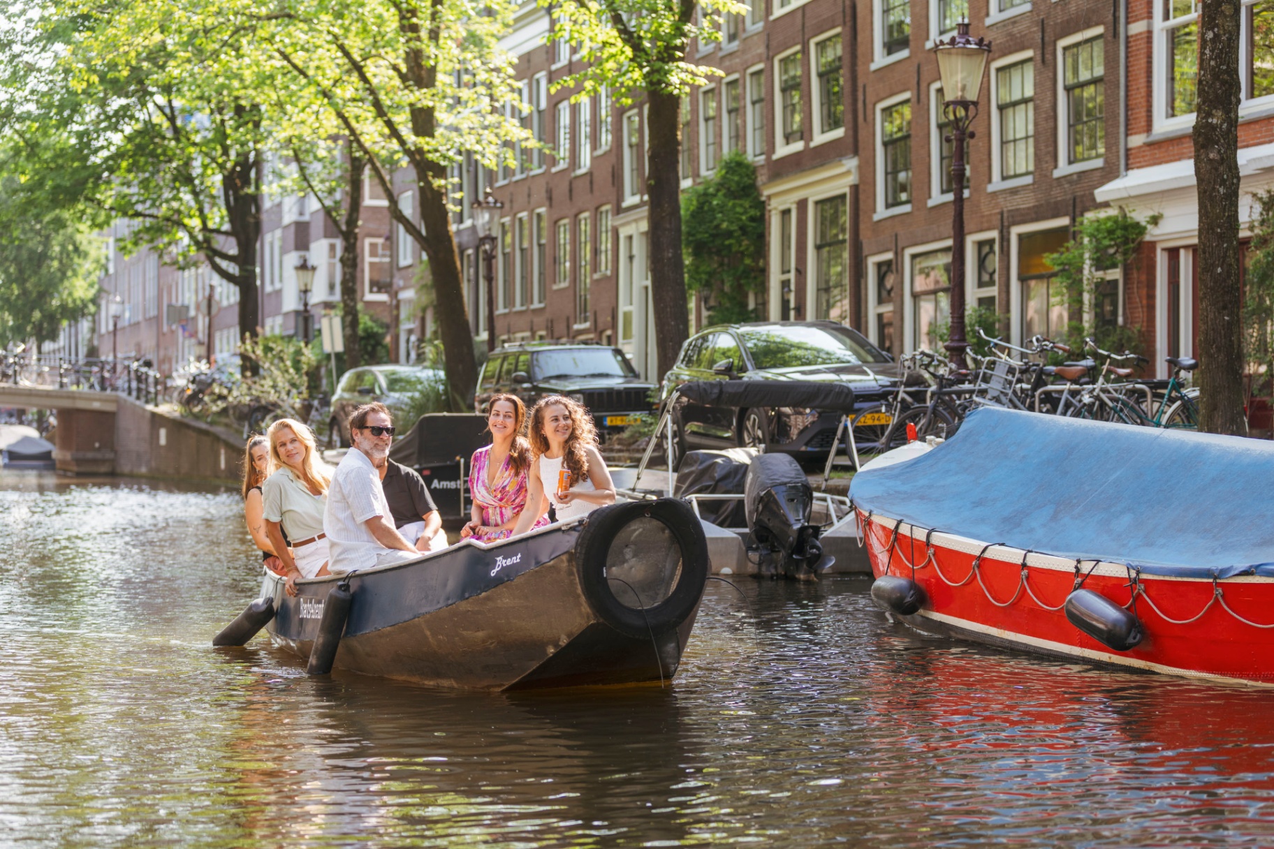 Familie vaart met sloep door Amsterdam